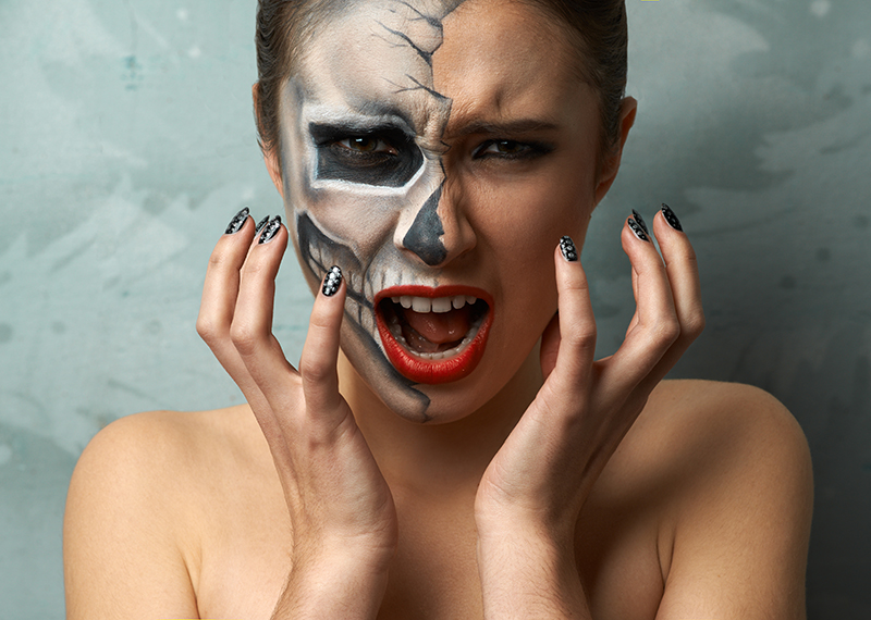 Woman with half face of halloween makeup