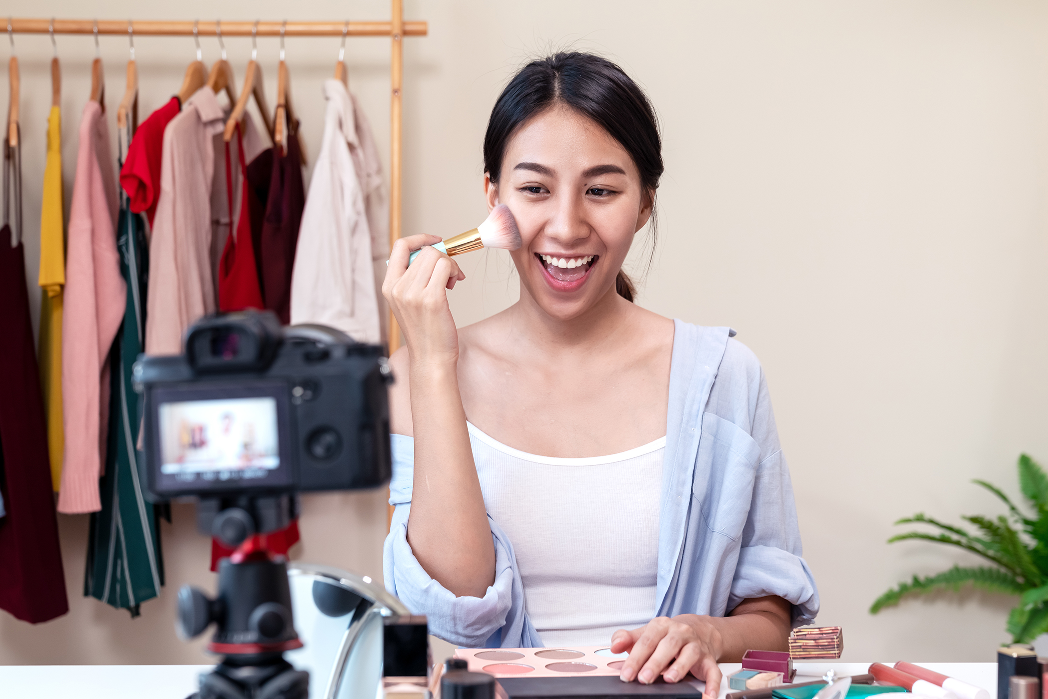 Woman doing make-up demonstration on video camera 